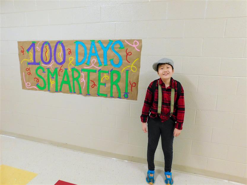boy next to 100 days smarter sign
